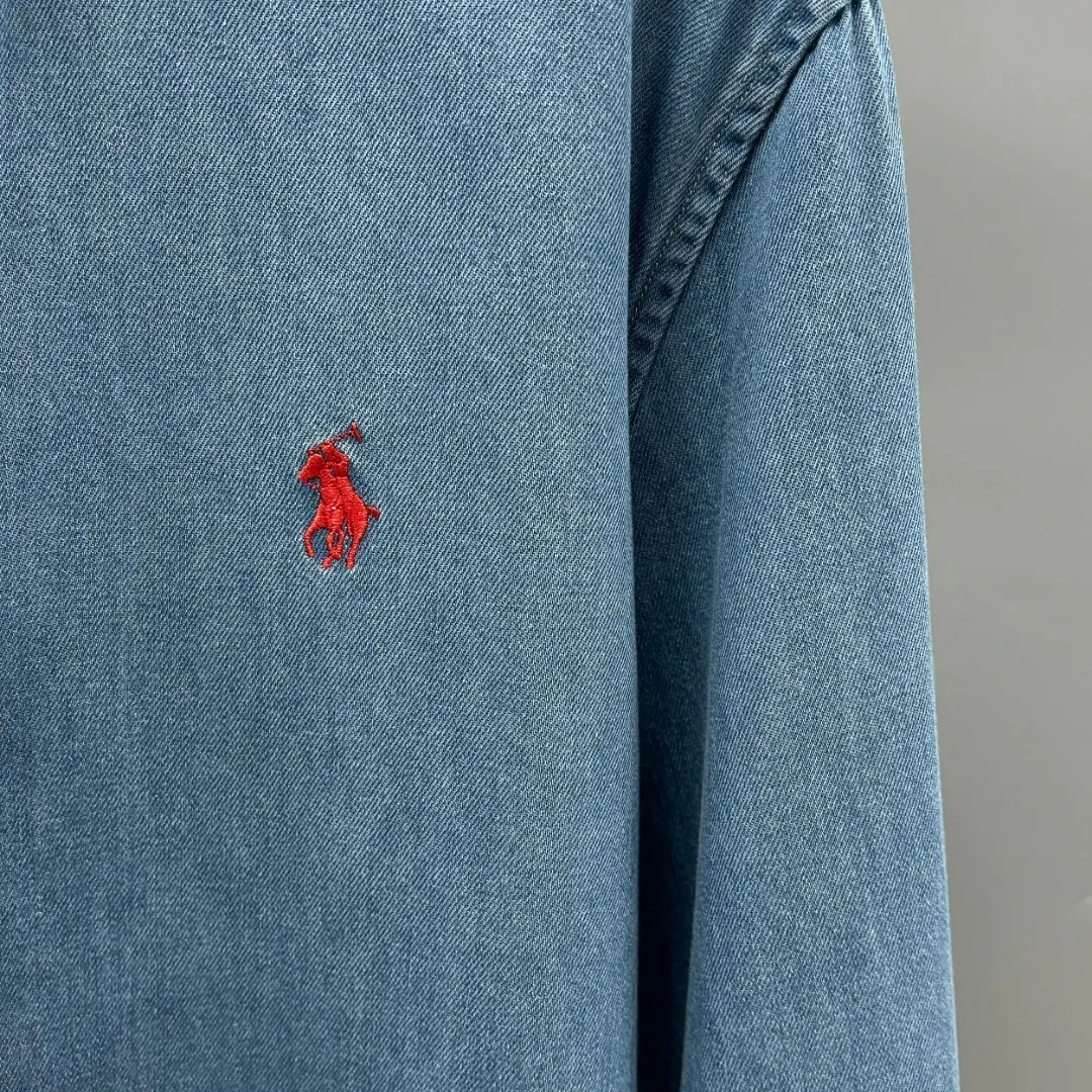 P220 Ralph Lauren/Ralph Lauren embroidered denim shirt is made of high-count combed cotton denim fabric. The yarn is even and fine. No impurity hairiness. You can feel the soft texture of cotton fiber when you touch it. Loose fit. The upper body is three-dimensional. The lines are smooth and natural. From the shoulder line to the waist line and then to the hem. The line transition is smooth. There are no unnecessary folds or accumulation. The whole body is neat and stretched. The chest is embellished with the iconic pony embroidery. It is simple but highly recognizable. The color transition of the embroidery thread is natural. The stitches are evenly spaced and uniform in size. The stitches can also connect naturally and the lines are smooth and not stiff. Size: S M L XL
